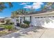 Close-up of a charming single-story home featuring an attached garage and landscaped front yard at 6127 Sw 84Th Place Rd, Ocala, FL 34476