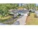 Charming single-story home featuring a lush green lawn, mature trees, and a long driveway leading to a two-car garage at 6127 Sw 84Th Place Rd, Ocala, FL 34476