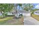 Charming home with well-manicured front yard and mature trees lining the driveway at 6127 Sw 84Th Place Rd, Ocala, FL 34476