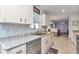 Bright kitchen featuring white cabinets, granite countertops, and stainless steel appliances at 6127 Sw 84Th Place Rd, Ocala, FL 34476