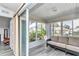 Bright sunroom with large windows and sliding glass doors, offering a cozy seating area and plenty of natural light at 6127 Sw 84Th Place Rd, Ocala, FL 34476