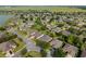 Aerial view of a charming residential neighborhood featuring tree-lined streets and well-manicured lawns near a tranquil lake at 7432 Sw 98Th Ave, Ocala, FL 34481