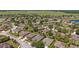 Aerial view of a community with manicured lawns, lush trees, and peaceful lakes in the distance at 7432 Sw 98Th Ave, Ocala, FL 34481