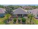 An eye-level aerial view of the home showcasing a well-manicured lawn and a screened-in lanai at 7432 Sw 98Th Ave, Ocala, FL 34481