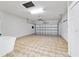 Spacious garage with neutral colors, tile flooring, overhead lighting, and an automatic garage door at 7432 Sw 98Th Ave, Ocala, FL 34481