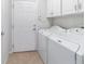 Laundry room with white washer and dryer units with white cabinetry and tiled floors at 7432 Sw 98Th Ave, Ocala, FL 34481