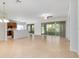 Spacious living room featuring tile floors, a ceiling fan, and sliding glass doors to the screened-in porch at 7432 Sw 98Th Ave, Ocala, FL 34481