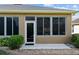 Close up of the screened-in porch with white trim and mature landscaping at 7432 Sw 98Th Ave, Ocala, FL 34481