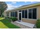 View of the screened-in porch with access door and well-maintained backyard at 7432 Sw 98Th Ave, Ocala, FL 34481