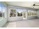 Bright sunroom featuring large windows, neutral carpeting, and a ceiling fan at 7432 Sw 98Th Ave, Ocala, FL 34481