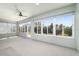 Bright sunroom featuring large windows, neutral carpeting, and a ceiling fan at 7432 Sw 98Th Ave, Ocala, FL 34481