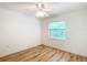 Neutral bedroom features sleek wood floors, a ceiling fan, and a large window bringing in plenty of light at 8051 Sw 115 Loop, Ocala, FL 34481