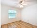 Neutral bedroom featuring sleek wood floors, a ceiling fan, and a large window bringing in plenty of light at 8051 Sw 115 Loop, Ocala, FL 34481