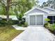 Exterior view of the home's screened two-car garage, showcasing the driveway and landscaping at 8051 Sw 115 Loop, Ocala, FL 34481