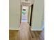 Hallway featuring sleek wood floors that lead to a bathroom with a white vanity and plenty of storage at 8051 Sw 115 Loop, Ocala, FL 34481