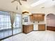 Well-lit kitchen featuring tiled floors, sliding glass doors, white appliances, and wooden cabinets at 8051 Sw 115 Loop, Ocala, FL 34481