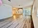 Open-concept living room featuring hardwood floors, windows, and an open entryway at 8051 Sw 115 Loop, Ocala, FL 34481