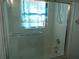 Bathroom featuring tiled shower over tub with glass doors and shower head at 8132 Fairways Cir # R103, Ocala, FL 34472