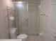 Bathroom featuring a glass enclosed shower, toilet and shelving at 8132 Fairways Cir # R103, Ocala, FL 34472