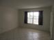 Cozy bedroom with neutral tile flooring, a window, and freshly painted walls at 8132 Fairways Cir # R103, Ocala, FL 34472