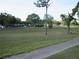 Open green space with mature trees and a sidewalk, perfect for recreation and relaxation at 8132 Fairways Cir # R103, Ocala, FL 34472