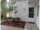 Welcoming front door with decorative security bars surrounded by beautiful greenery and mulch at 8132 Fairways Cir # R103, Ocala, FL 34472