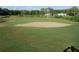 Panoramic view of a golf course with a large sand trap and green grass at 8132 Fairways Cir # R103, Ocala, FL 34472