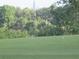 A picturesque golf green with a flag, surrounded by lush greenery and trees at 8132 Fairways Cir # R103, Ocala, FL 34472