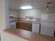 Bright kitchen features upper and lower cabinets, white appliances, and a breakfast bar at 8132 Fairways Cir # R103, Ocala, FL 34472