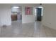 Bright living room featuring neutral tile flooring, a view to the kitchen and access to the front entry at 8132 Fairways Cir # R103, Ocala, FL 34472