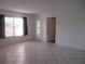 Spacious living room with tile flooring, large windows, and a doorway to another room at 8132 Fairways Cir # R103, Ocala, FL 34472