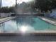 Community pool with sparkling blue water surrounded by lush landscaping and comfortable lounge chairs at 8132 Fairways Cir # R103, Ocala, FL 34472