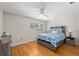 Bedroom featuring wood floors, ceiling fan, a window, and bed with blue floral bedding at 8625 Sw 94Th Ln # D, Ocala, FL 34481
