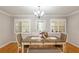 Cozy dining space illuminated by a chandelier, featuring shuttered windows and a charming wooden dining set at 8625 Sw 94Th Ln # D, Ocala, FL 34481