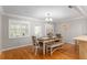 Charming dining room featuring a modern chandelier, wood floors, and a dining table with bench seating at 8625 Sw 94Th Ln # D, Ocala, FL 34481