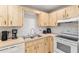 Efficient kitchen featuring light wood cabinets, subway tile backsplash, and essential appliances for everyday cooking at 8625 Sw 94Th Ln # D, Ocala, FL 34481