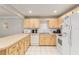 Practical kitchen with light wood cabinets, a breakfast bar, white appliances, and a clean, functional design at 8625 Sw 94Th Ln # D, Ocala, FL 34481