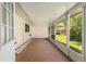 Enclosed patio with an open door and screened windows showcasing a well-maintained yard at 8625 Sw 94Th Ln # D, Ocala, FL 34481