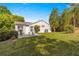 A well-maintained backyard with a patio set, green lawn, and lush landscaping on a sunny day at 8750 Sw 108Th St, Ocala, FL 34481