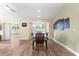 Bright dining room featuring wood floors, a window with plantation shutters, and modern art piece at 8750 Sw 108Th St, Ocala, FL 34481
