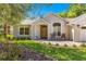 Close up of the home's entrance with an arched window and seating area on a sunny day at 8750 Sw 108Th St, Ocala, FL 34481