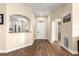 Spacious hallway with wood floors, leading to kitchen with white cabinets and stainless-steel appliances at 8750 Sw 108Th St, Ocala, FL 34481