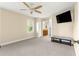 Spacious bedroom with a ceiling fan, tv and ensuite bathroom featuring a carpeted floor at 8750 Sw 108Th St, Ocala, FL 34481
