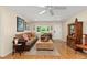 Cozy living room with hardwood floors, inviting sofa, and views of the landscaped yard at 8833 Sw 98Th Street Rd # E, Ocala, FL 34481