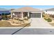 Charming home featuring manicured landscaping, a covered front porch, and a two-car garage at 8878 Sw 103Rd Cir, Ocala, FL 34481