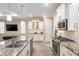 Bright kitchen with white cabinetry, granite counters, stainless appliances and a breakfast bar overlooking the living space at 8878 Sw 103Rd Cir, Ocala, FL 34481