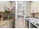 Bright laundry room with a sink, white cabinetry, and modern washer and dryer, leading into the open-concept living area at 8878 Sw 103Rd Cir, Ocala, FL 34481
