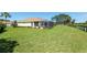 Well-maintained backyard showcasing a large lawn, white fencing, and a screened-in patio for outdoor relaxation and entertainment at 8904 Sw 84Th Cir, Ocala, FL 34481