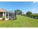 Spacious backyard with a screened patio, green lawn, and perimeter fence providing a private and serene outdoor space at 8904 Sw 84Th Cir, Ocala, FL 34481