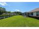 Expansive backyard featuring a screened-in lanai and a white fence, perfect for outdoor enjoyment and privacy at 8904 Sw 84Th Cir, Ocala, FL 34481